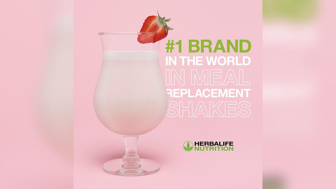 Glass of meal replacement shake with strawberry on pink background promoting Herbalife Nutrition