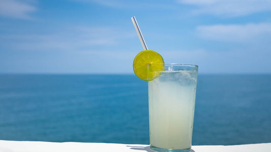 Glass of refreshing aloe vera drink with water and fresh aloe leaves